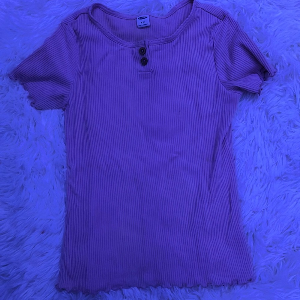 It is pink with 2 buttons on it with ruffles